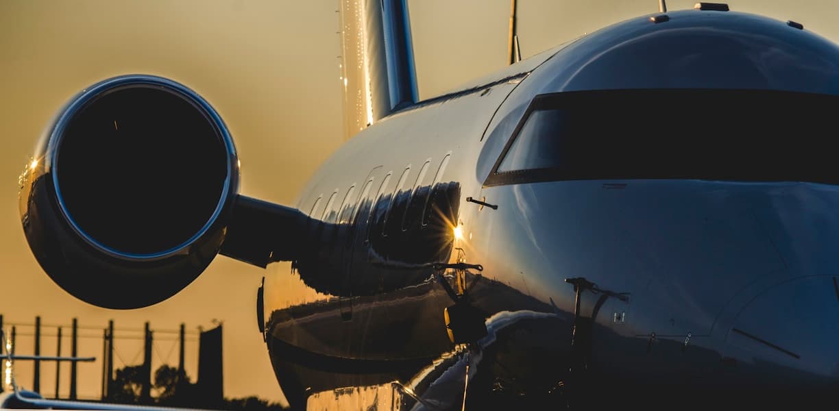 Private jet nose and engine lit by golden-hour light on the ramp